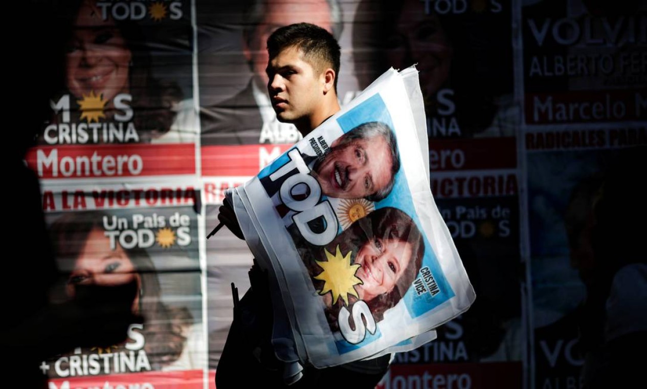 Homem segura uma bandeira com foto do presidente Alberto Fernández e da vice Cristina Kirchner Foto: UESLEI MARCELINO / REUTERS