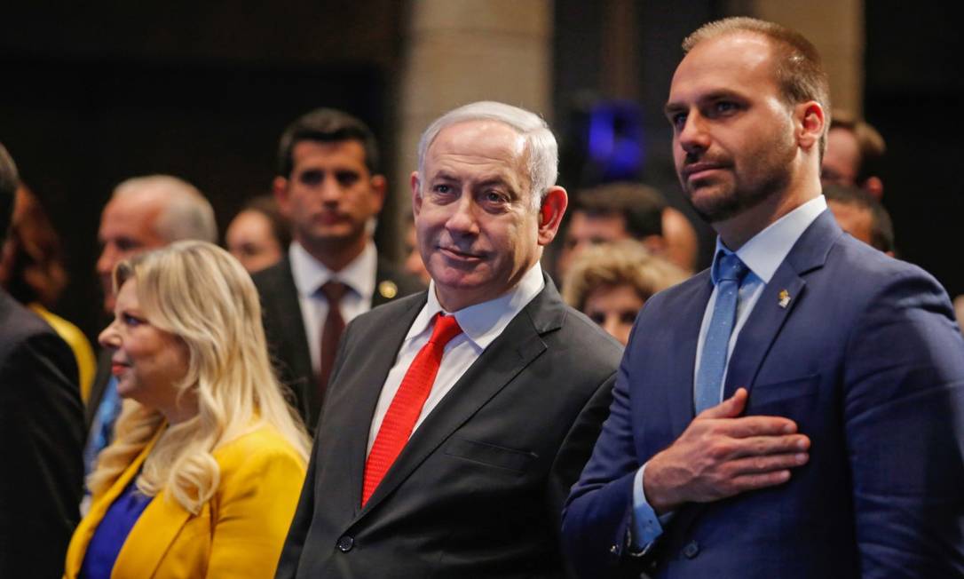 O primeiro-ministro de Israel, Benjamin Netanyahu, entre o deputado federal Eduardo Bolsonaro e sua mulher Sara, durante a cerimônia da inauguração do escritório de negócios do Brasil em Jerusalém Foto: GIL COHEN-MAGEN / AFP