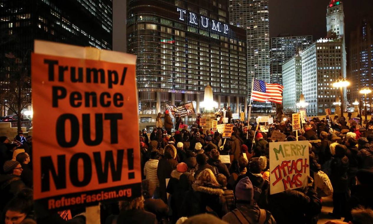 Cartaz pede a saída de Donald Trump e do vice Mike Pence, em Chicago, na noite de terça Foto: Kamil Krzaczynski / Reuters