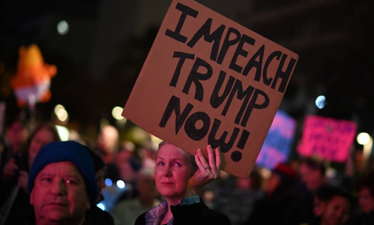 As pessoas se manifestam em apoio ao impeachment do presidente dos EUA, Donald Trump, na véspera do esperado voto de impeachment da Câmara dos Deputados, 17 de dezembro de 2019, no centro de Los Angeles Foto: Robyn Beck / AFP