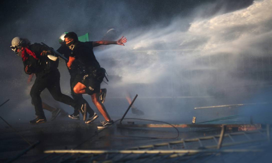 Manifestantes são atacados com jatos d'água durante protestos no Chile Foto: Ricardo Moraes / REUTERS