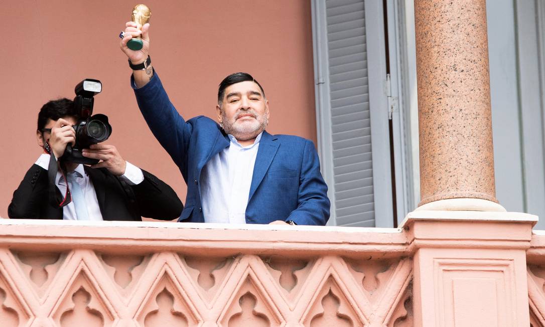 Diego Maradona mostra uma pequena réplica do troféu da Copa do Mundo na sacada da Casa Rosada, em Buenos Aires Foto: STRINGER / REUTERS
