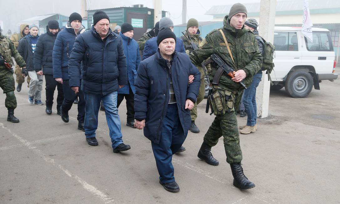 Detentos são escoltados por militares das autoproclamadas Repúblicas de Donetsk e Lugansk, no Leste da Ucrânia, durante troca de prisioneiros com o governo de Kiev Foto: ALEXANDER ERMOCHENKO / REUTERS