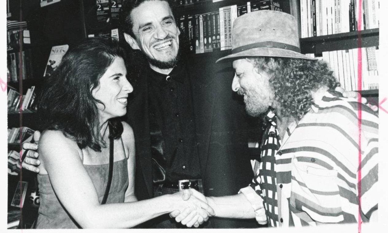 O cantor Geraldo Azevedo cumprimenta Kika Seixas, viúva de Raul Seixas, ao lado de Zé Ramalho, em 1997 Foto: Cristina Granato / Divulgação