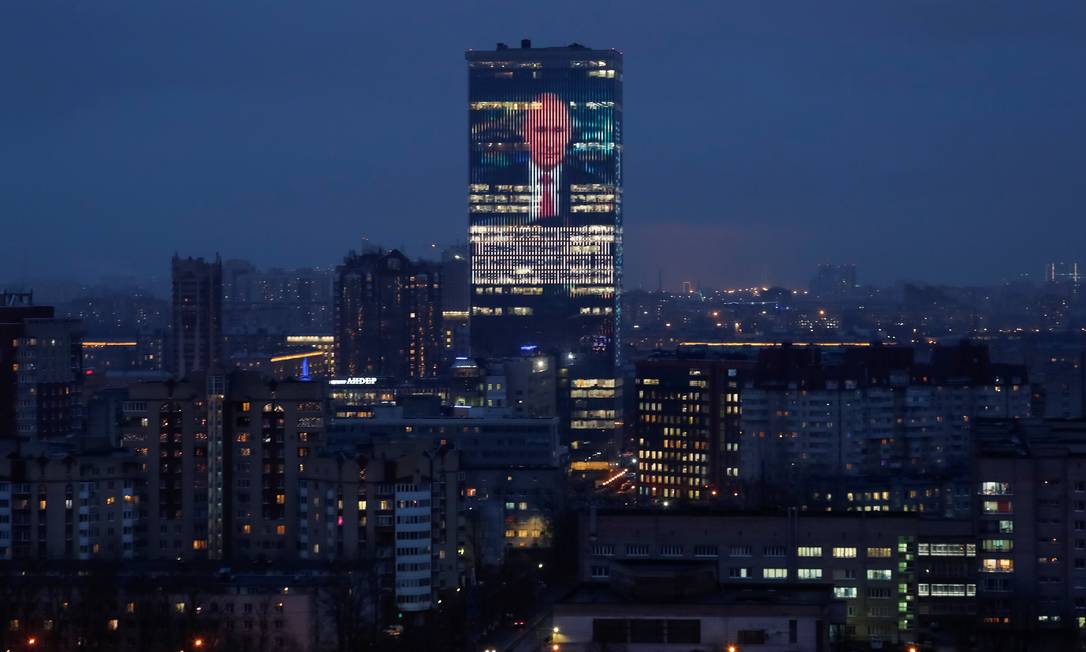 Telão instalada em prédio comercial de São Petersburgo mostra imagem do presidente Vladimir Putin, durante o discurso desta quarta-feira Foto: ANTON VAGANOV / REUTERS