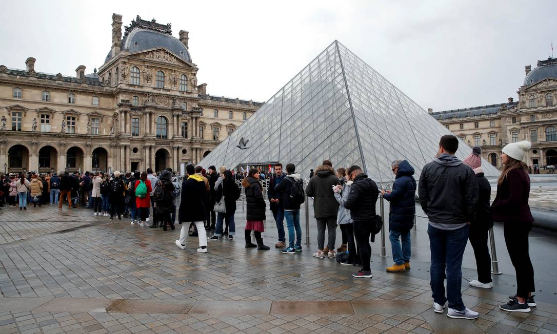 Turistas fazem fila enquanto funcionários fecham entrada da Pirâmide do Louvre, em Paris, em manifestação contra a reforma da Previdência proposta pelo presidente Emmanuel Macron Foto: GONZALO FUENTES / REUTERS
