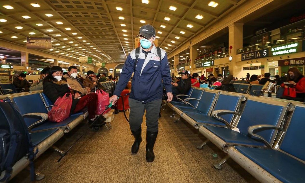 Membro da equipe desinfeta estação ferroviária de Hankou Foto: STR / AFP