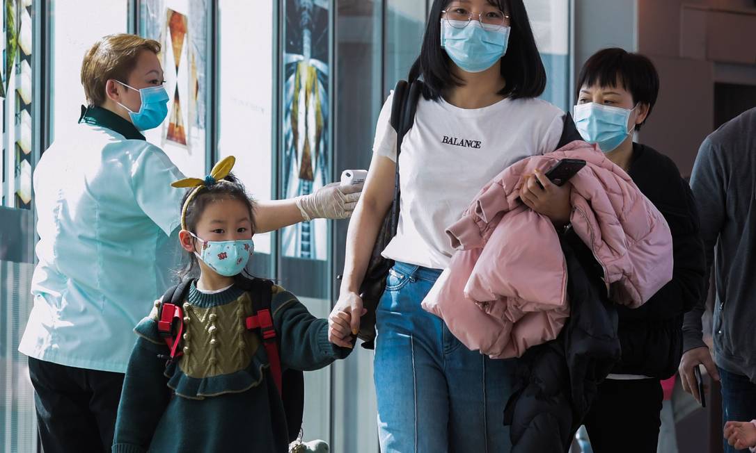 Funcionária vistoria passageiros que chegam da China no Aeroporto Internacional de Changi, em Cingapura Foto: ROSLAN RAHMAN/AFP