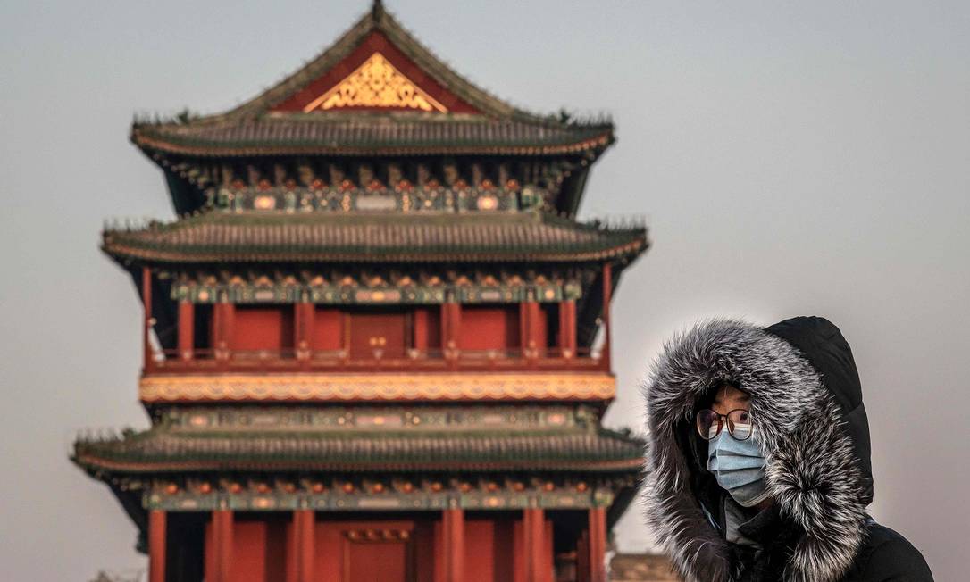Em Pequim, pessoas se protegem contra o coronavírus Foto: NICOLAS ASFOURI / AFP