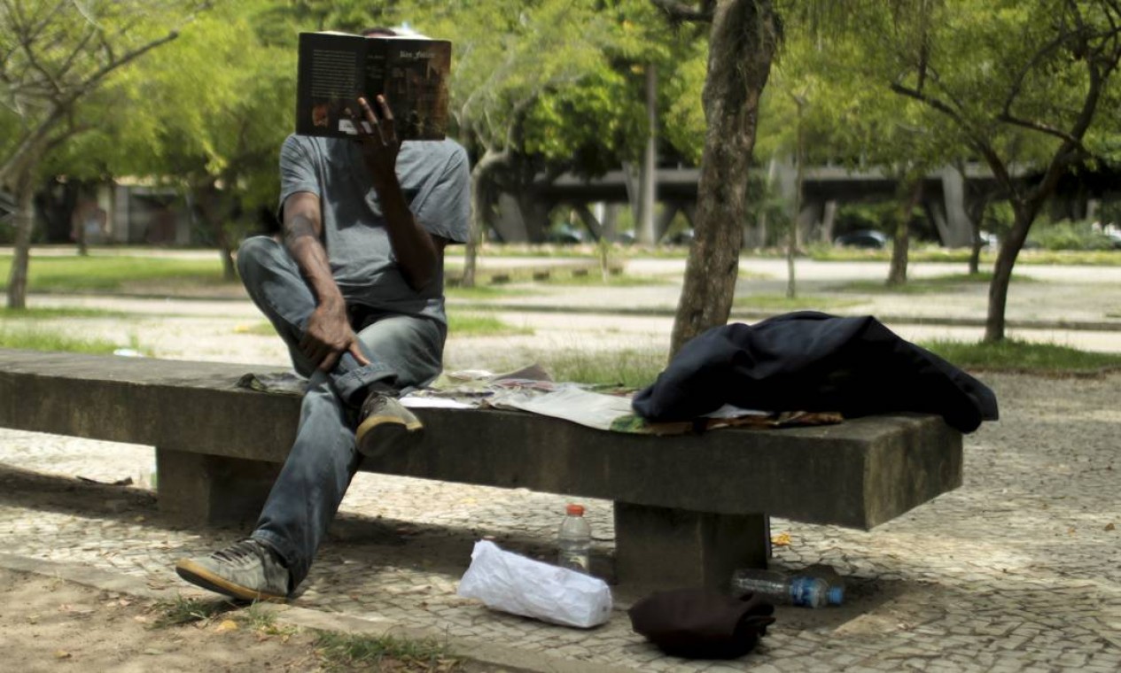 Morador de rua, que pediu anonimato, lê nos arredores do MAM Foto: Gabriel de Paiva / Agência O Globo
