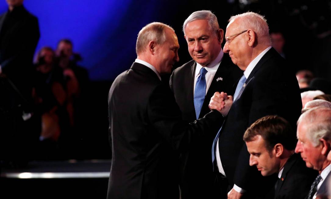 Premier israelense, Benjamin Netanyahu, observa os presidentes Vladimir Putin, da Rússia, e Reuven Rivlin, de Israel, no Forum Global do Holocausto; no rodapé, vê-se o líder francês Emmanuel Macron e o príncipe Charles, do Reino Unido Foto: RONEN ZVULUN / REUTERS