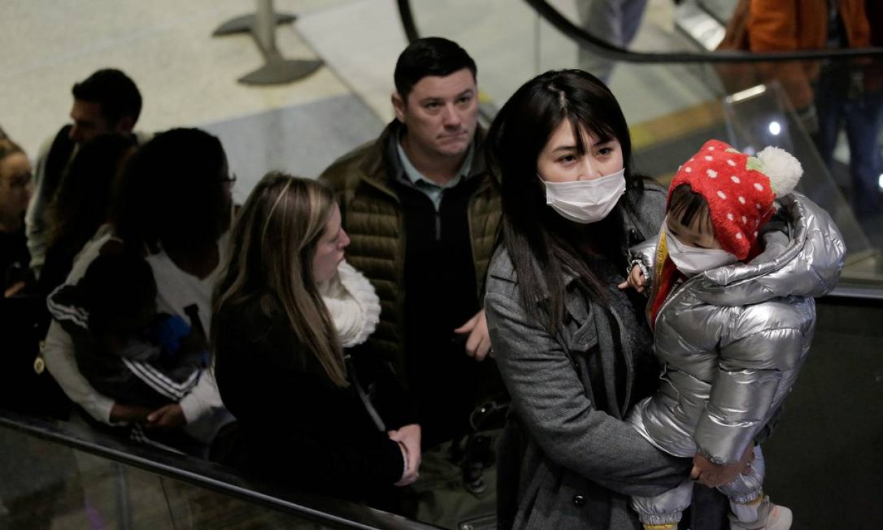 Viajantes usando máscaras chegam em voo direto da China, depois que porta-voz do Centro de Controle e Prevenção de Doenças dos EUA (CDC) disse que um viajante do país asiático foi a primeira pessoa nos Estados Unidos a ser diagnosticada com o coronavírus Foto: David Ryder / REUTERS