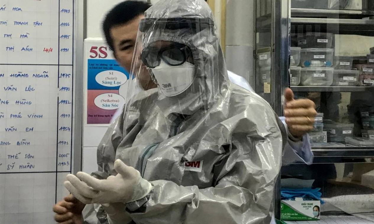 O vice-ministro da Saúde do Vietnã, Nguyen Truong Son, veste um traje de proteção antes de entrar em uma área de isolamento para visitar os dois primeiros casos da nova infecção por coronavírus, no hospital Cho Ray, na cidade de Ho Chi Minh Foto: BACH DUONG / AFP