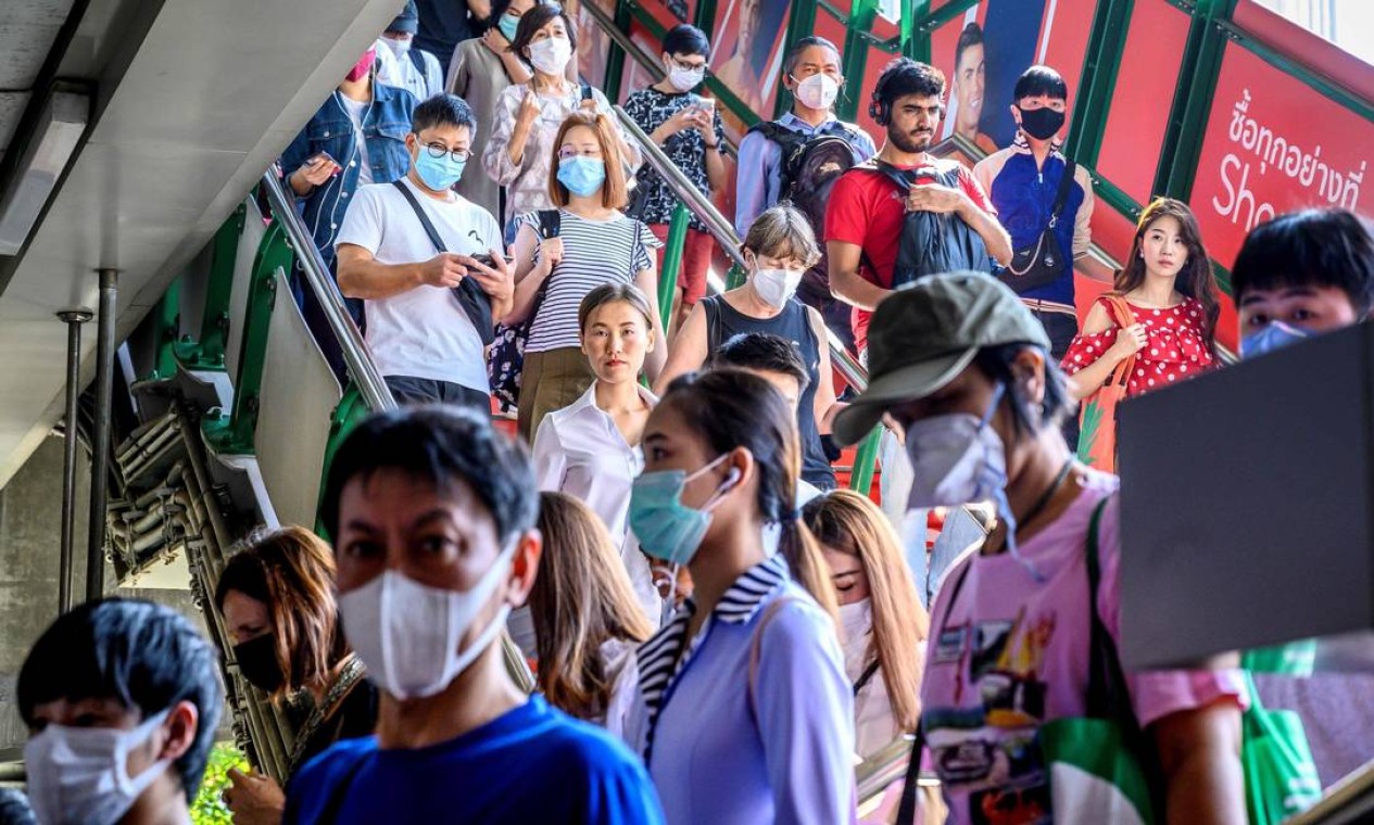 Pessoas com máscaras chegam à estação de trem BTS Sky, em Bangcoc, na Tailândia. País detectou oito casos de coronavírus até esta segunda-feira (27). Foto: MLADEN ANTONOV / AFP