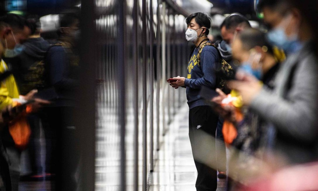 Passageiros com máscaras esperam trem em uma plataforma do metrô durante feriado público do Ano Novo Lunar do Rato, em Hong Kong Foto: ANTHONY WALLACE / AFP