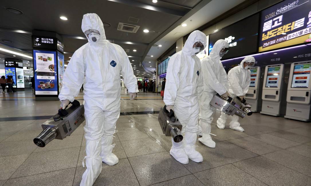 Trabalhadores desinfetam terminal de ônibus em Gwangju, na Coreia do Sul, um dos 14 países atingidos pelo coronavírus originário de Wahun, na China Foto: - / AFP