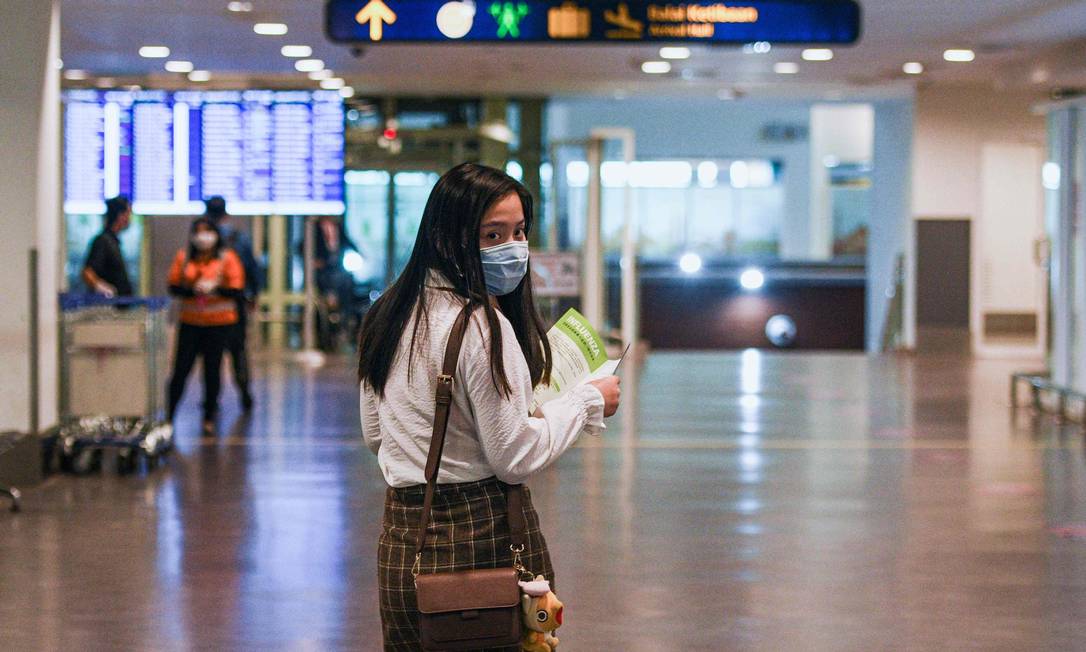 Passageira usando máscara de proteção na chegada ao Aeroporto Internacional de Kuala Lumpur, em Sepang. A Tailândia detectou 14 casos até agora do novo coronavírus Foto: MOHD RASFAN / AFP