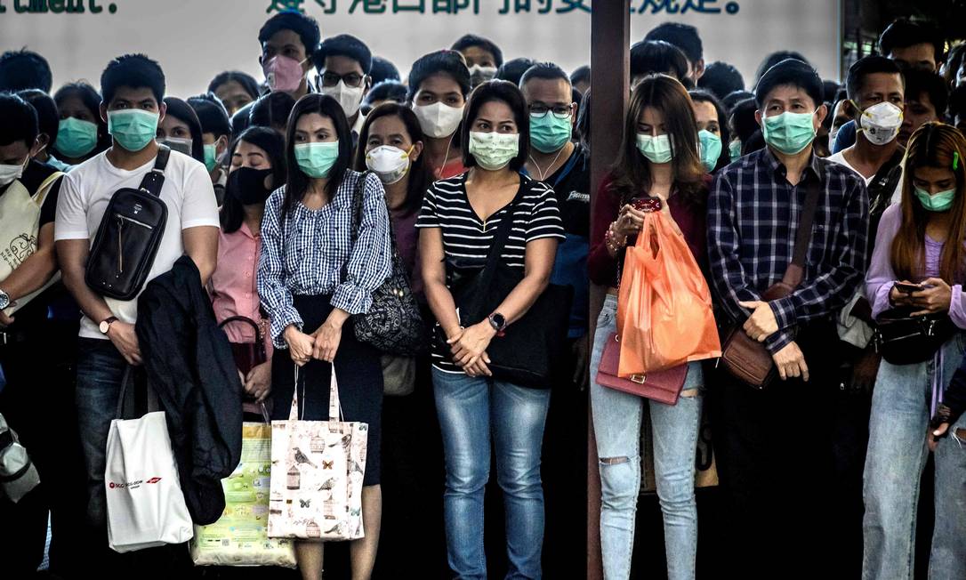 Passageiros de máscara esperam por barco em Bangkok, Tailândia Foto: MLADEN ANTONOV / AFP