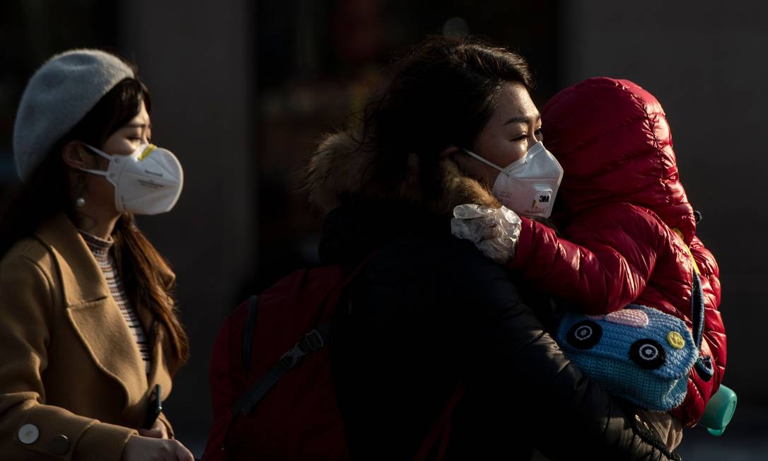 Turistas de máscara chegam à estação de trem de Pequim, na China. Foto: NOEL CELIS / AFP