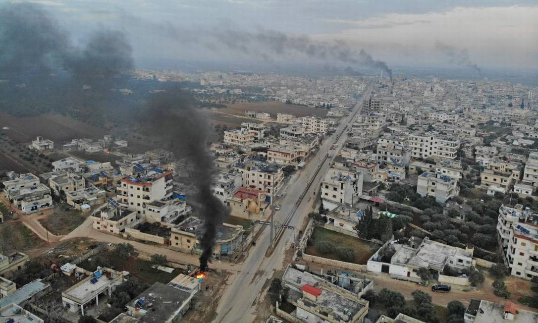 Vista aérea da fumaça subindo dos pneus queimados pelos sírios na tentativa de impedir ataques aéreos, em meio a confrontos na cidade de Binnish, na província de Idlib, no noroeste da Síria. Foto: OMAR HAJ KADOUR / AFP