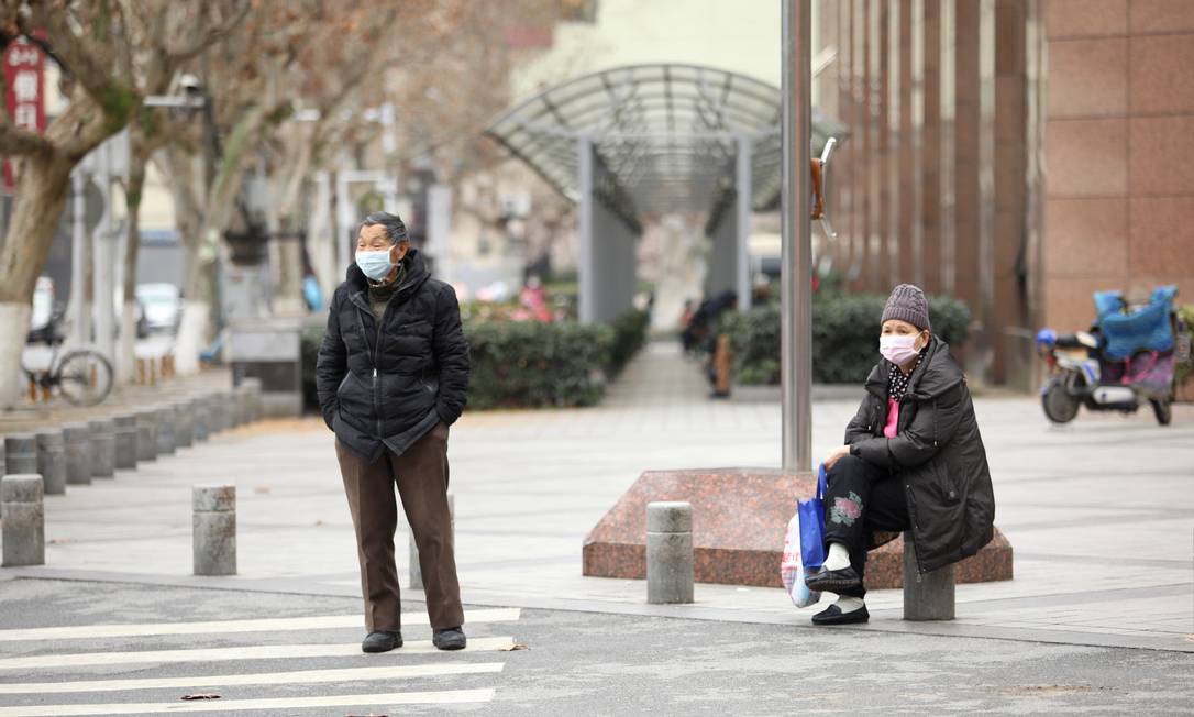 Pedestres usam máscaras em rua de Wuhan, na províncie de Hubei, epicentro do coronavírus Foto: REUTERS