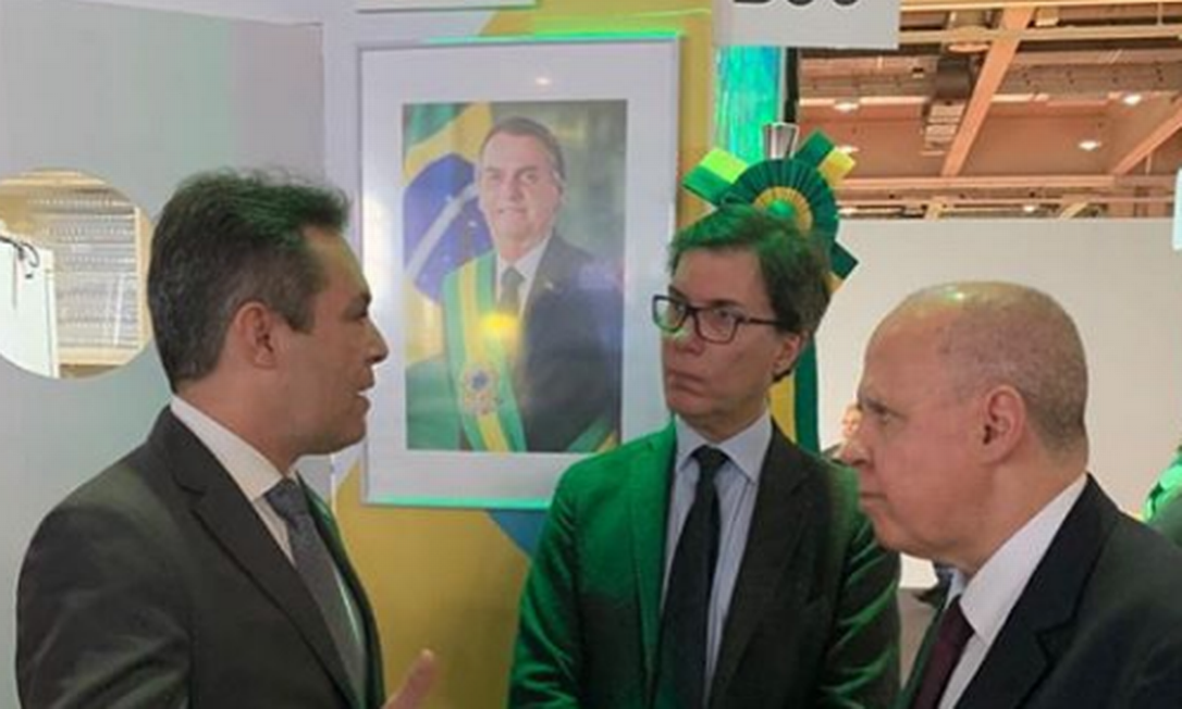 Foto de Bolsonaro em estande da Embratur em Milão. Ao centro, Gilson Machado, presidente da estatal Foto: Reprodução