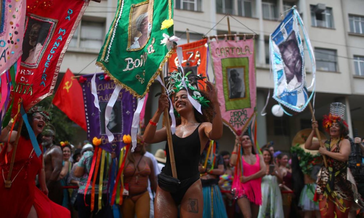 Folionas levam estandartes à frente do Cordão do Boitatá durante desfile que arrastou foliões pelas ruas do centro Foto: PILAR OLIVARES / REUTERS