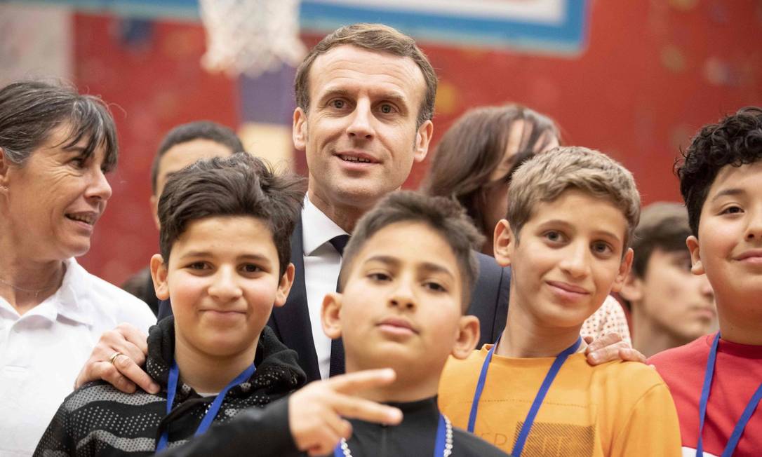 O presidente francês, Emmanuel Macron, posa com jovens na visita a Mulhouse durante uma viagem sobre o tema da reconquista republicana e da luta contra o separatismo islâmico, no Leste da França Foto: JEAN-FRANCOIS BADIAS / AFP