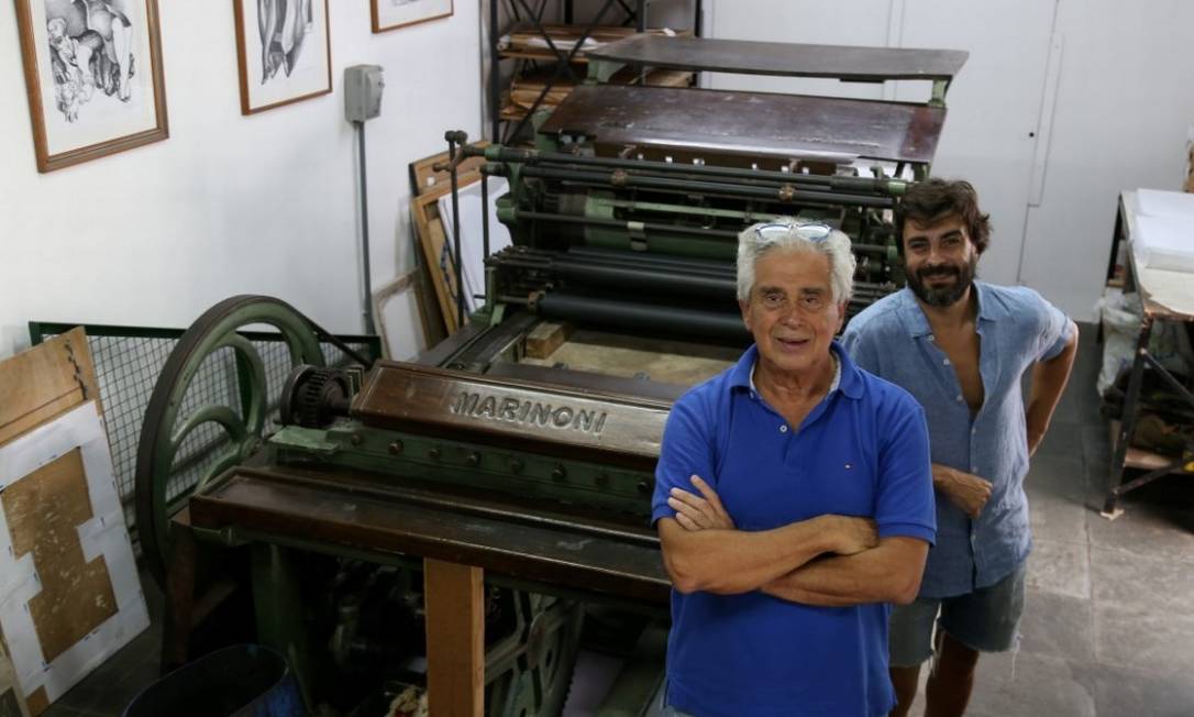 Guilherme (à frente) e Gustavo Rodrigues junto à prensa litográfica de mais de quatro toneladas e que data de 1860 Foto: Pedro Teixeira / Agência O Globo