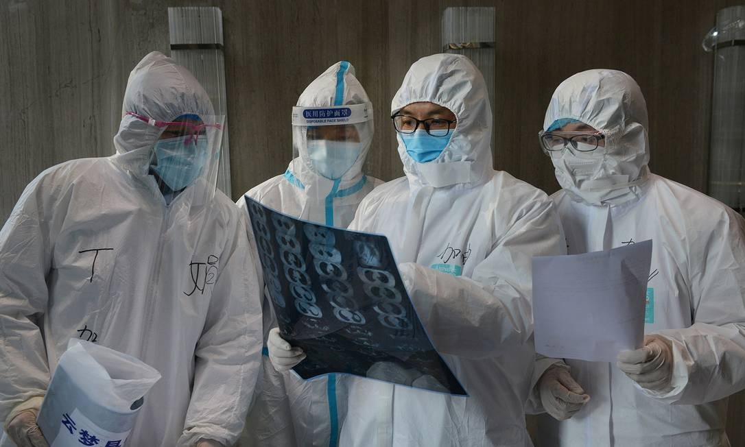 Médicos examinam exame em hospital na China, onde o coronavírus está sendo transmitido por pessoas sem sintomas Foto: CHINA DAILY / REUTERS