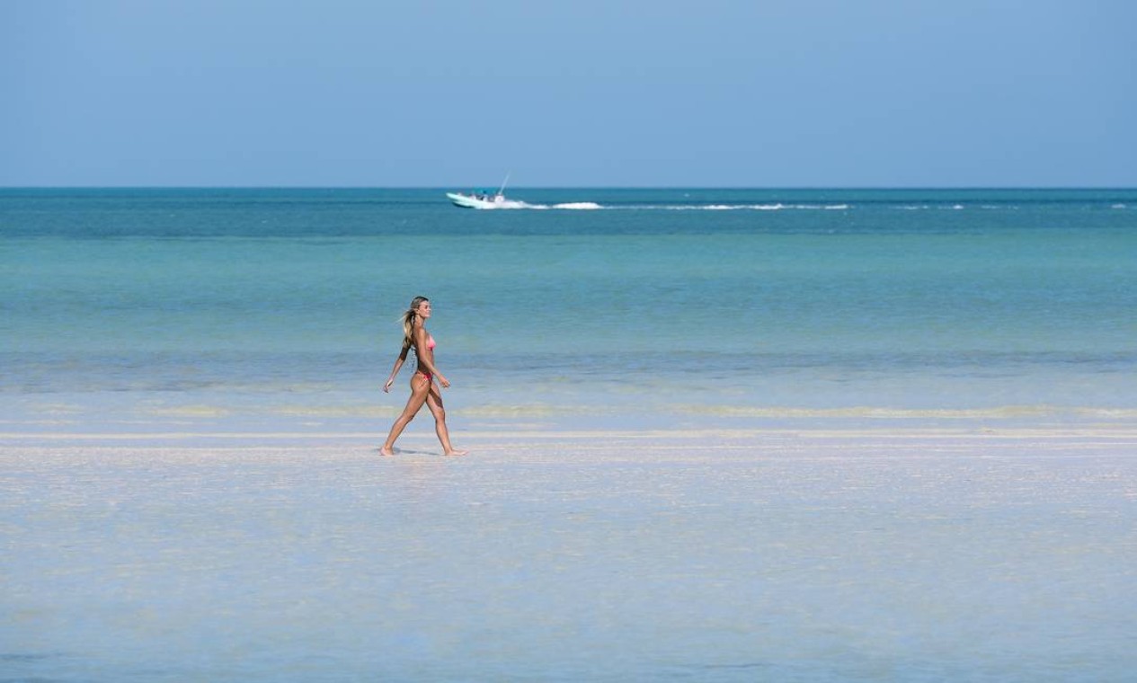 Banhista caminha numa praia da Costa Mujeres, região vizinha a Cancún, no Caribe mexicano Foto: Divulgação