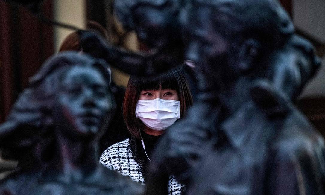 Mulher com máscara protetora em Xangai. Foto: NOEL CELIS / AFP