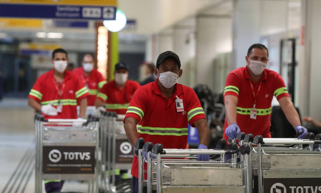 Funcionários usam máscaras protetoras no Aeroporto de Guarulhos Foto: AMANDA PEROBELLI / REUTERS