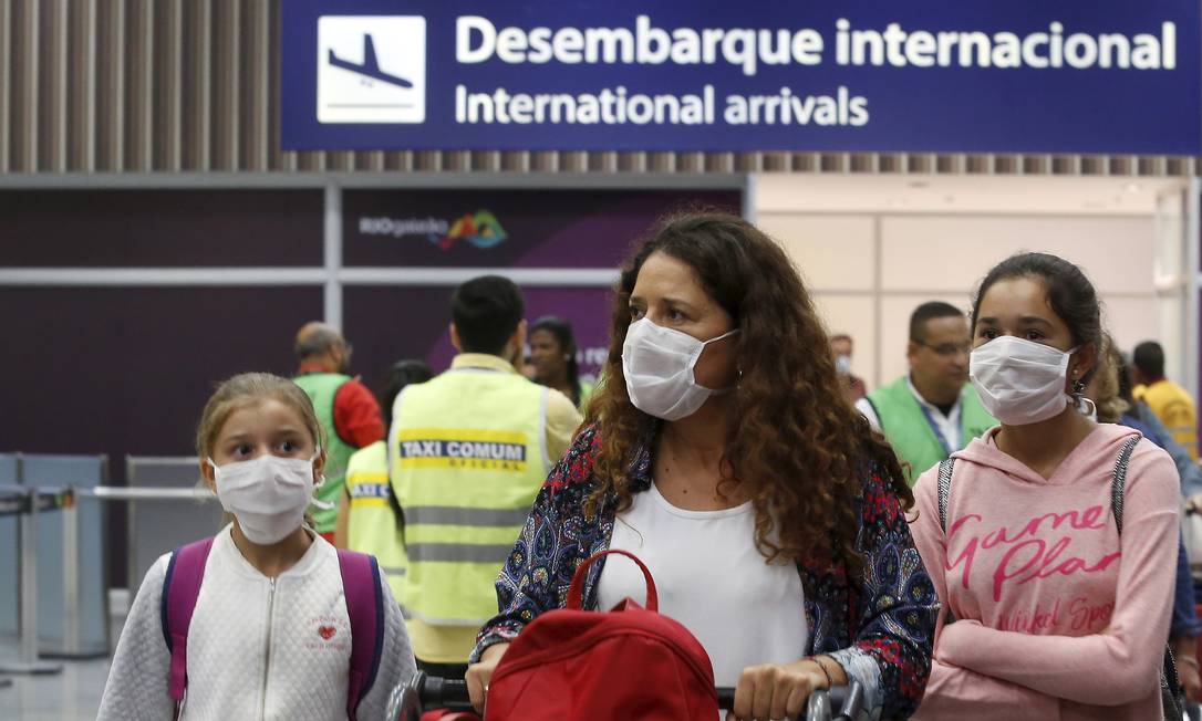 Passageiros desembarcam no terminal internacional do Aeroporto do Galeão, no Rio, portando máscaras de proteção Foto: FABIANO ROCHA / Agência O Globo