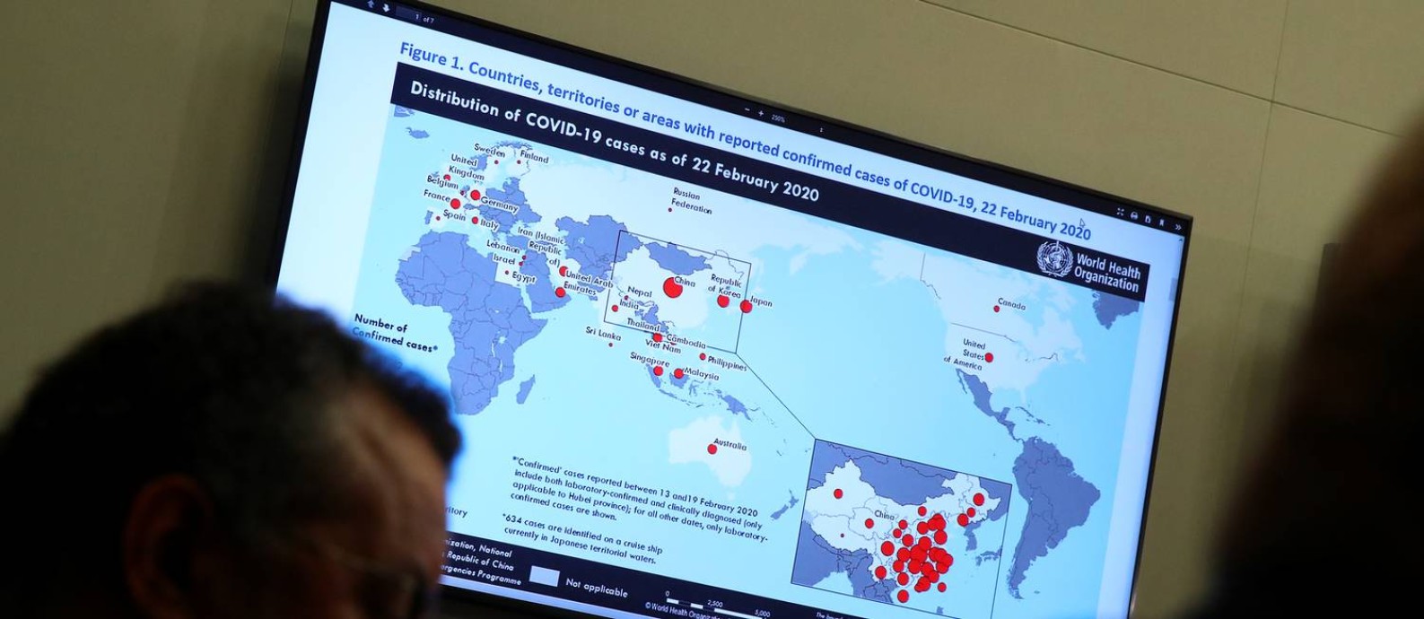 Mapa indica distribuição do novo coronavírus pelo mundo durante coletiva de imprensa na Organização Mundial da Saúde (OMS), em Genebra, na Suíça. À esquerda, o diretor-geral da entidade, Tedros Adhanom Ghebreyesus Foto: DENIS BALIBOUSE / REUTERS