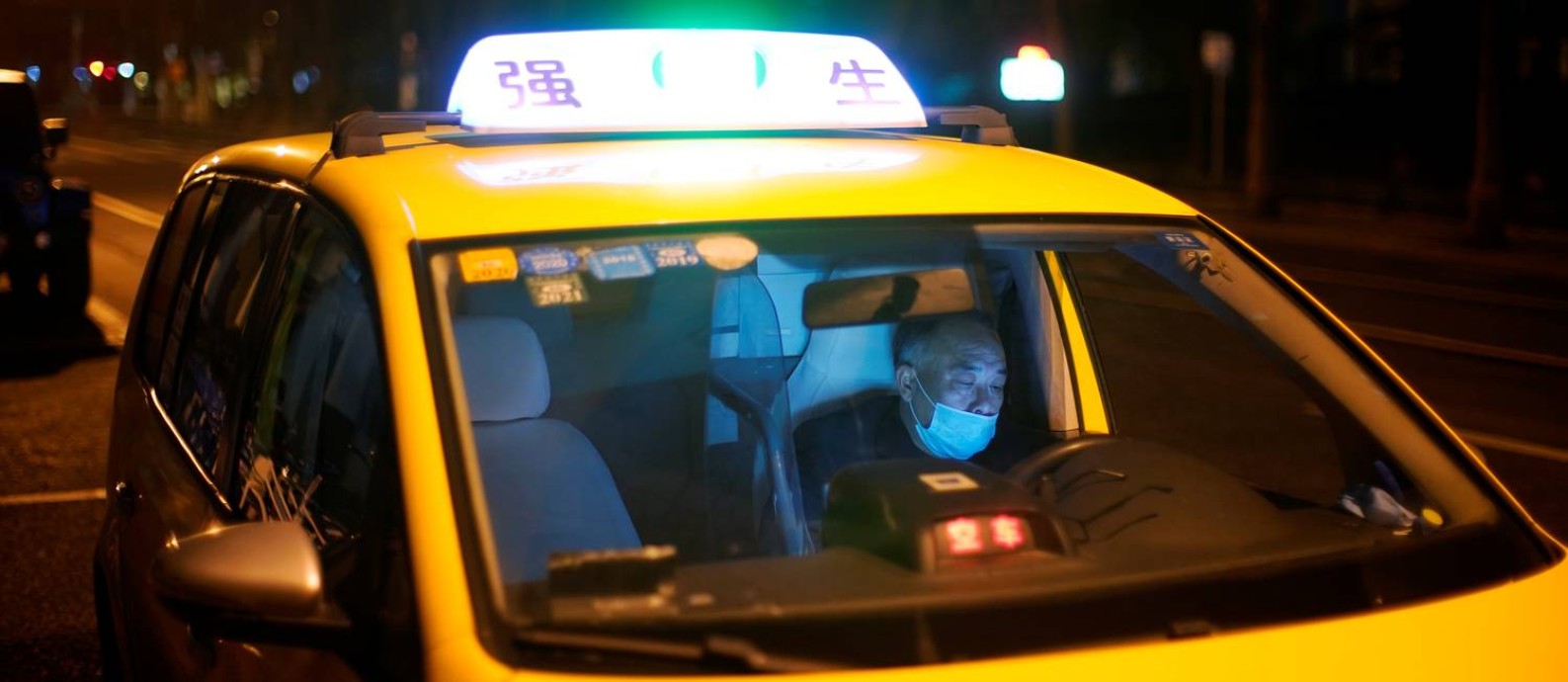 Motorista de táxi em Xangai, na China, com máscara contra o coronavírus; profissionais estão entre os mais expostos com a epidemia de Covid-19 Foto: ALY SONG / REUTERS