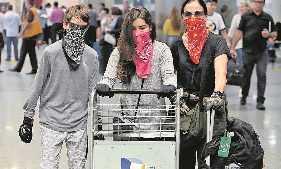 Desembarque de passageiros no Aeroporto Internacional do Galeão: máscaras improvisadas e luvas para evitar infecções Foto: FABIANO ROCHA/27-2-2020