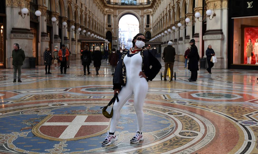 Lembrança de viagem com máscara: turista na famosa Galeria Vittorio Emanuele II, em Milão Foto: Miguel Medina/AFP / Miguel Medina/AFP 