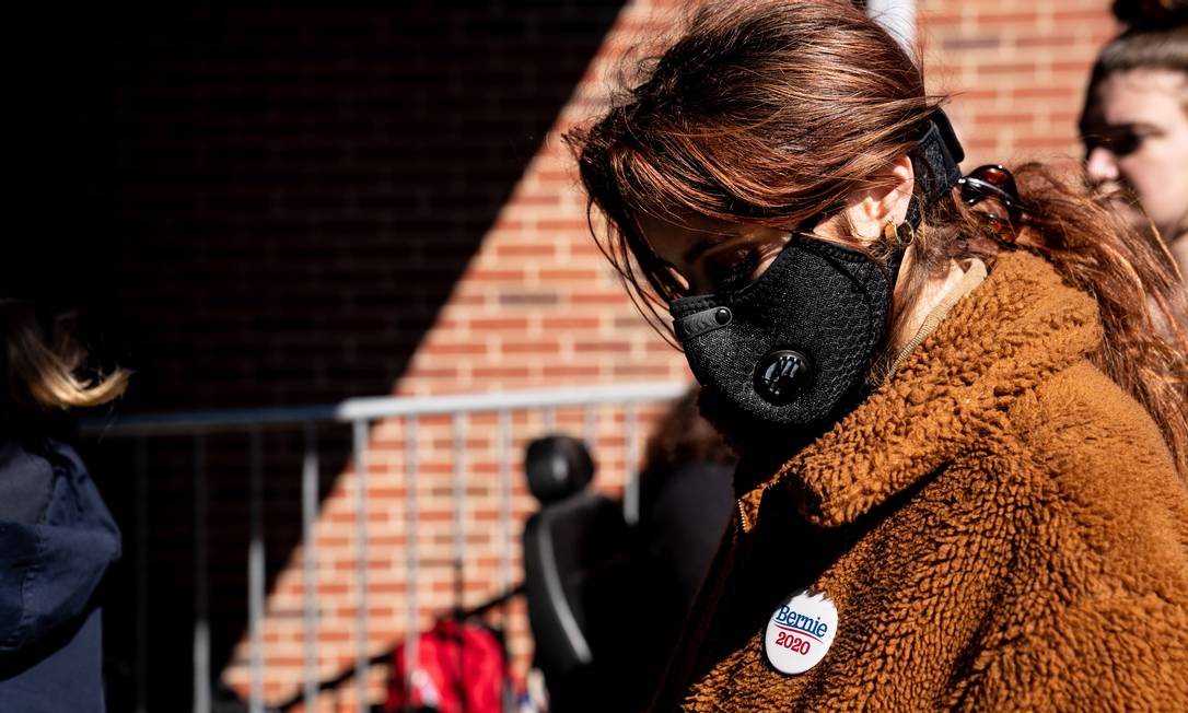 Eleitora de Bernie Sanders usa máscara antes de discurso de Bernie Sanders na Carolina do Norte, no dia 27 de fevereiro Foto: ERIN SCHAFF / NYT
