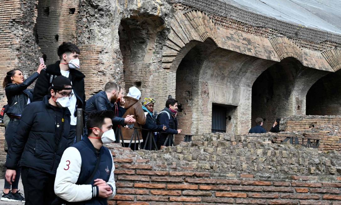 Turistas usam máscaras enquanto visitam o Coliseu, em Roma Foto: TIZIANA FABI / AFP