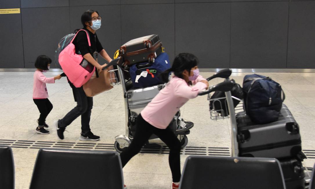 Passageiros vindos de Pequim desembarcam no Aeroporto Internacional de Guarulhos usando máscaras Foto: Fotoarena / Agência O Globo