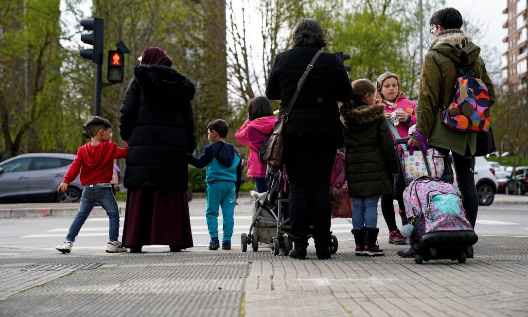 Pais e filhos deixam uma instituição de ensino primária após o anúncio do governo sobre o fechamento de escolas como prevenção ao coronavírus, na cidade espanhola de Vitória Foto: VINCENT WEST / REUTERS