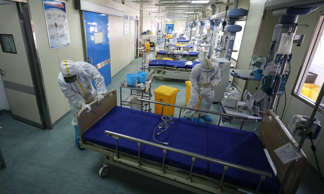 Após redução expressiva no número de casos de coronavírus na China, profissionais de saúde convertem ala que era usada para isolamento de pacientes com Covid-19 para o atendimento de demais pacientes em hospital de Wuhan, epicentro global da nova doença Foto: STR / AFP