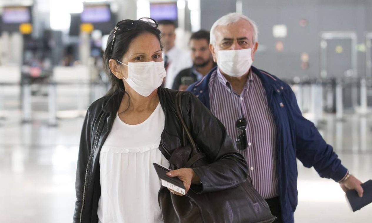 Lucelena Costa, de 52 anos, que mora há 20 anos na Itália e o italiano Troiano Enrico, de 65 anos embarcaram para a Europa, no Aeroporto Internacional de Guarulhos, usando máscara de proteção Foto: Edilson Dantas / Agência O Globo
