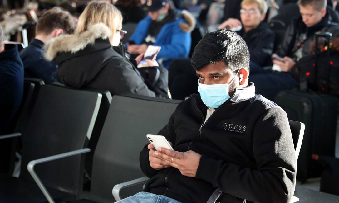 Homem com máscara espera seu voo no aeroporto de Heathrow, em Londres Foto: Hannah McKay / REUTERS