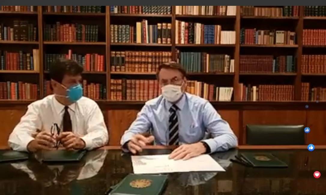 Com máscaras no rosto, Bolsonaro faz transmissão ao vivo com ministro da Saúde Foto: Reprodução