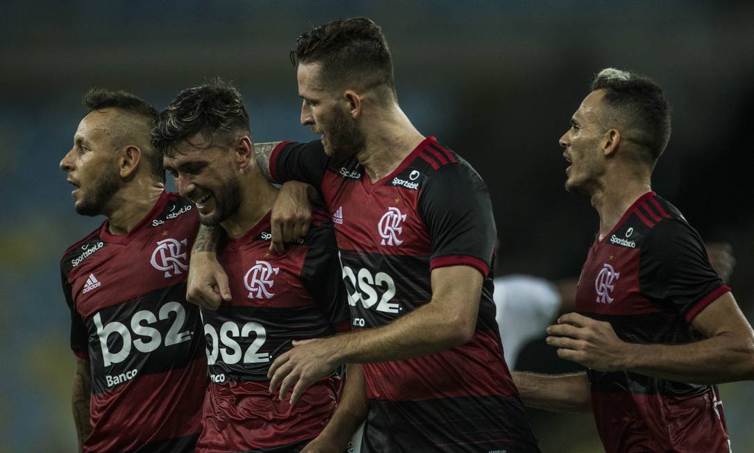 Jogadores do Flamengo se abraçam para comemorar o gol de Arrascaeta contra a Portuguesa, último jogo do time no Estadual Foto: Guito Moreto / Agência O Globo