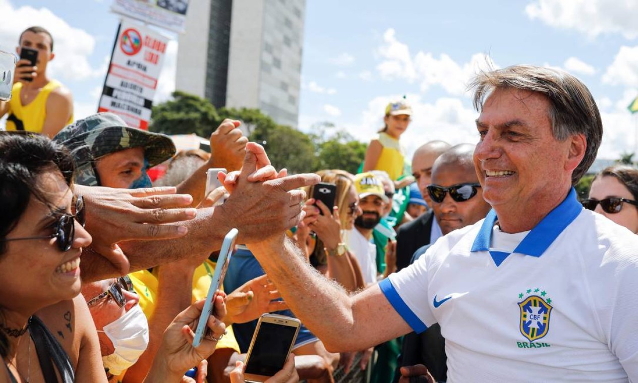 Presidente Jair Bolsonaro cumprimenta seus apoiadores durante manifestação em Brasília, amplamente divulgada pelo próprio. Ele deveria ter ficado em isolamento social por ter tido contato com pelo menos 10 membros de sua equipe Foto: SERGIO LIMA / AFP - 15/03/2020