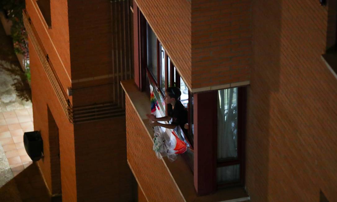 Em isolamento, em Madri, mulher aplaude pela janela. Evento foi organizado pelas redes sociais para mostrar gratidão aos trabalhadores da Saúde que atuam em meio à pandemia de coronavírus Foto: SERGIO PEREZ / REUTERS