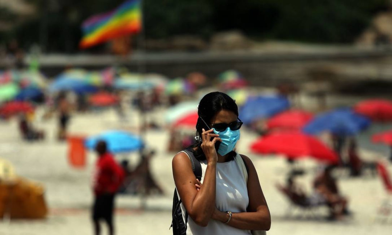 Uma mulher usa máscara enquanto fala ao telefone no calçadão do Arpoador, na Zona Sul do Rio Foto: Fabio Motta / Agência O Globo